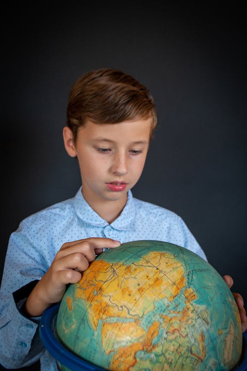 Free A Boy Studying the Globe Stock Photo