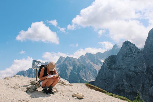 A Hiker Sitting while Writing in a Paper