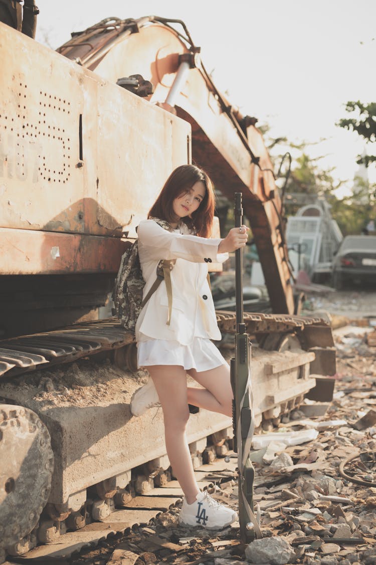 Beautiful Woman Holding A Sniper While Looking At The Camera