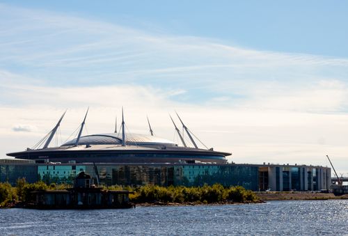 Free Scenic view of a modern stadium with unique architecture by the water on a sunny day. Stock Photo