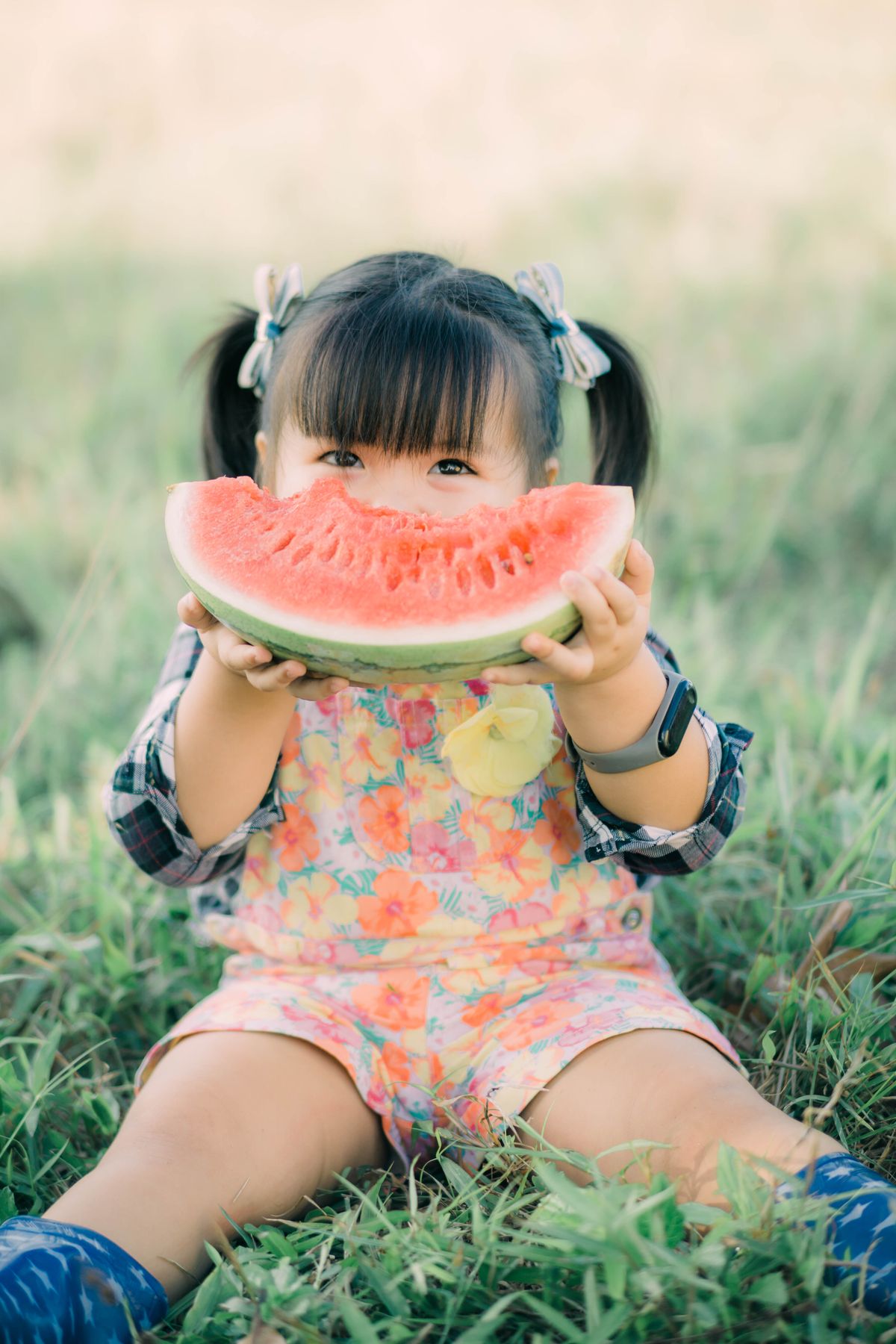 A happy child eating watermelon on the grass