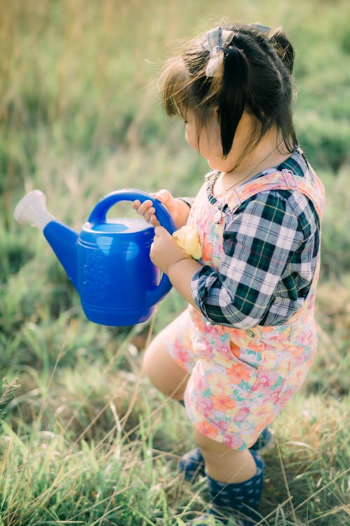 Cute Kid Holding a Blue Watering Can