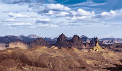 Free A breathtaking view of a mountain range under a vivid blue sky with scattered clouds. Stock Photo