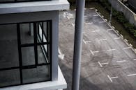 这张当代建筑立面鸟瞰图邻近空停车区，展现了城市建筑设计