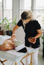 Woman Applying Clay Mask on Client's Face