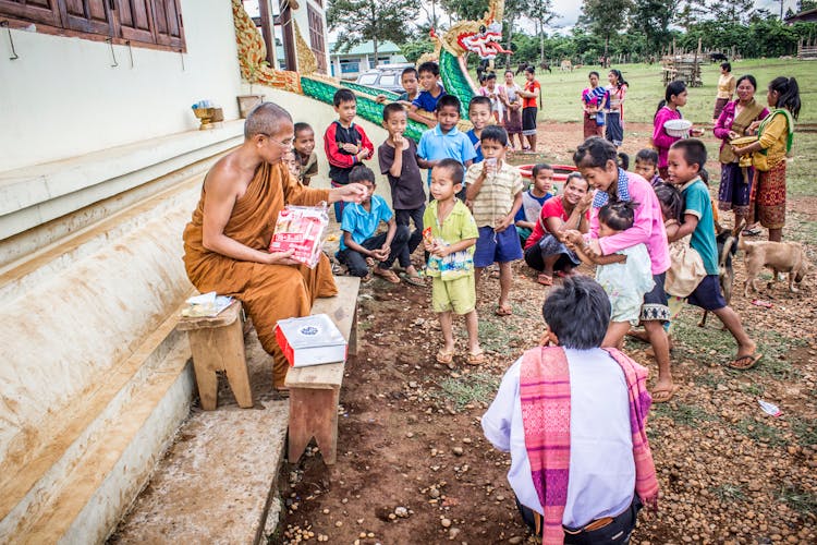 Group Of Children In Front Of Monk At Daytime