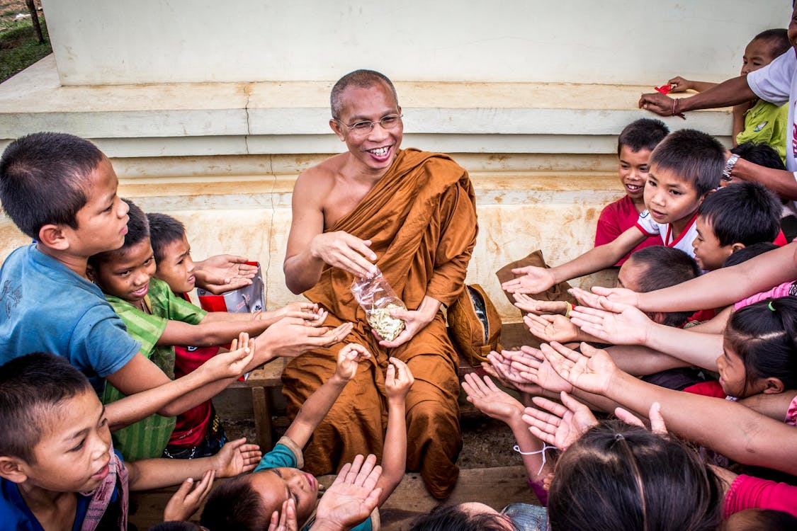 Free Man in Monk Dress Between Group of Children Stock Photo