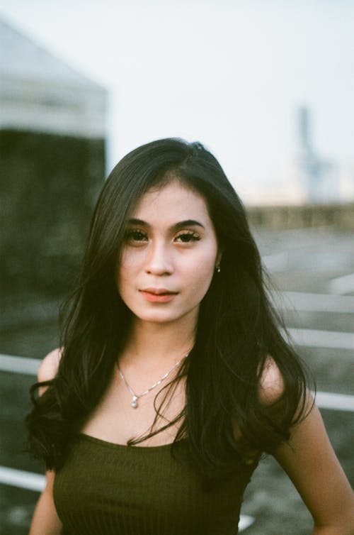 Portrait Photo of a Woman in a Green Top Looking at the Camera