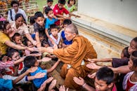 一位僧人与孩子们分享礼物，捕捉到了同情心与文化传统的瞬间