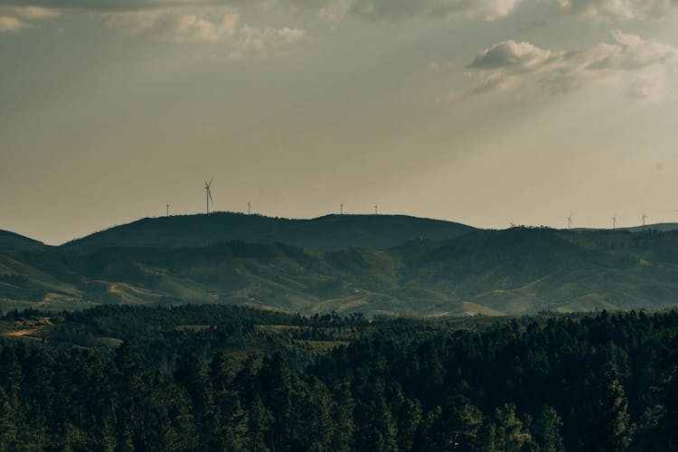 Windmills On Horizon In Mountain Landscape