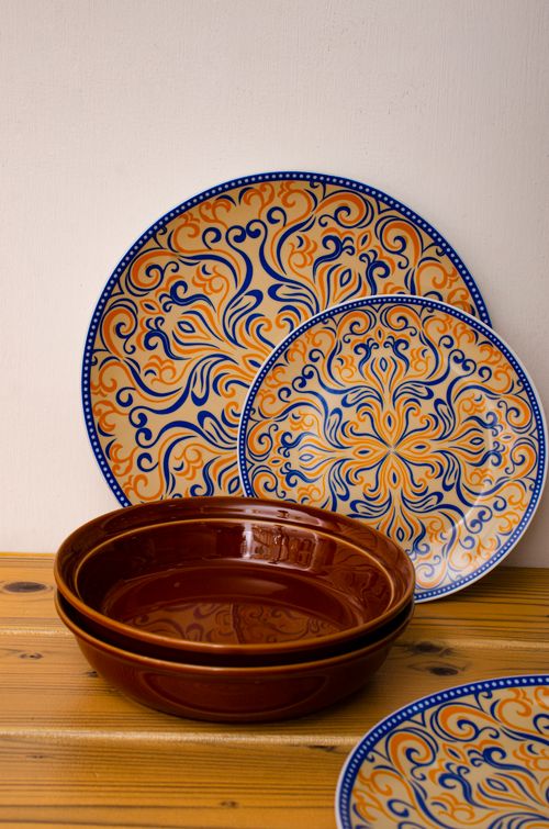 Free Artistic ceramic plates with ornate patterns on a wooden surface. Stock Photo