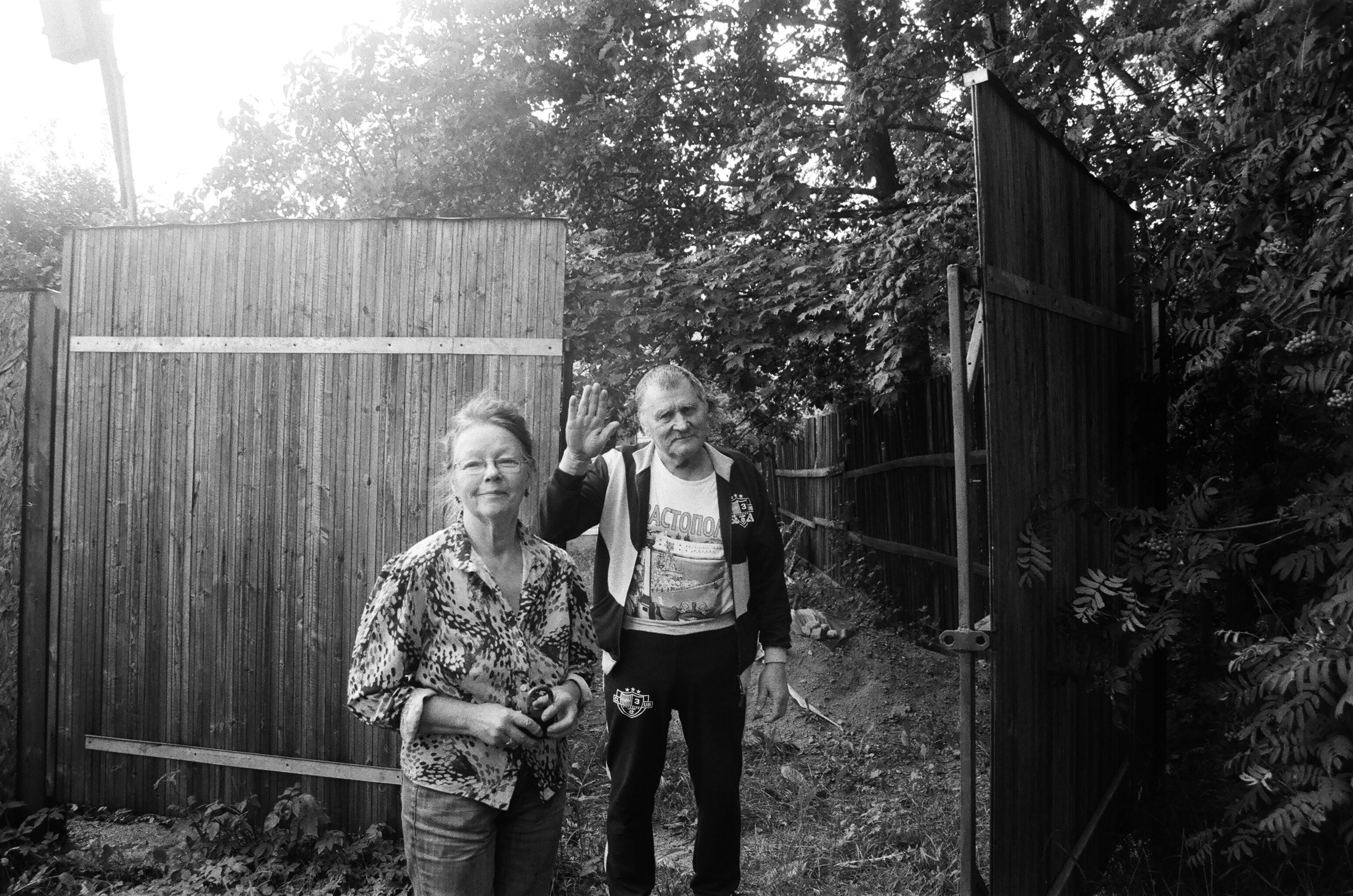 man standing backyard fence gate