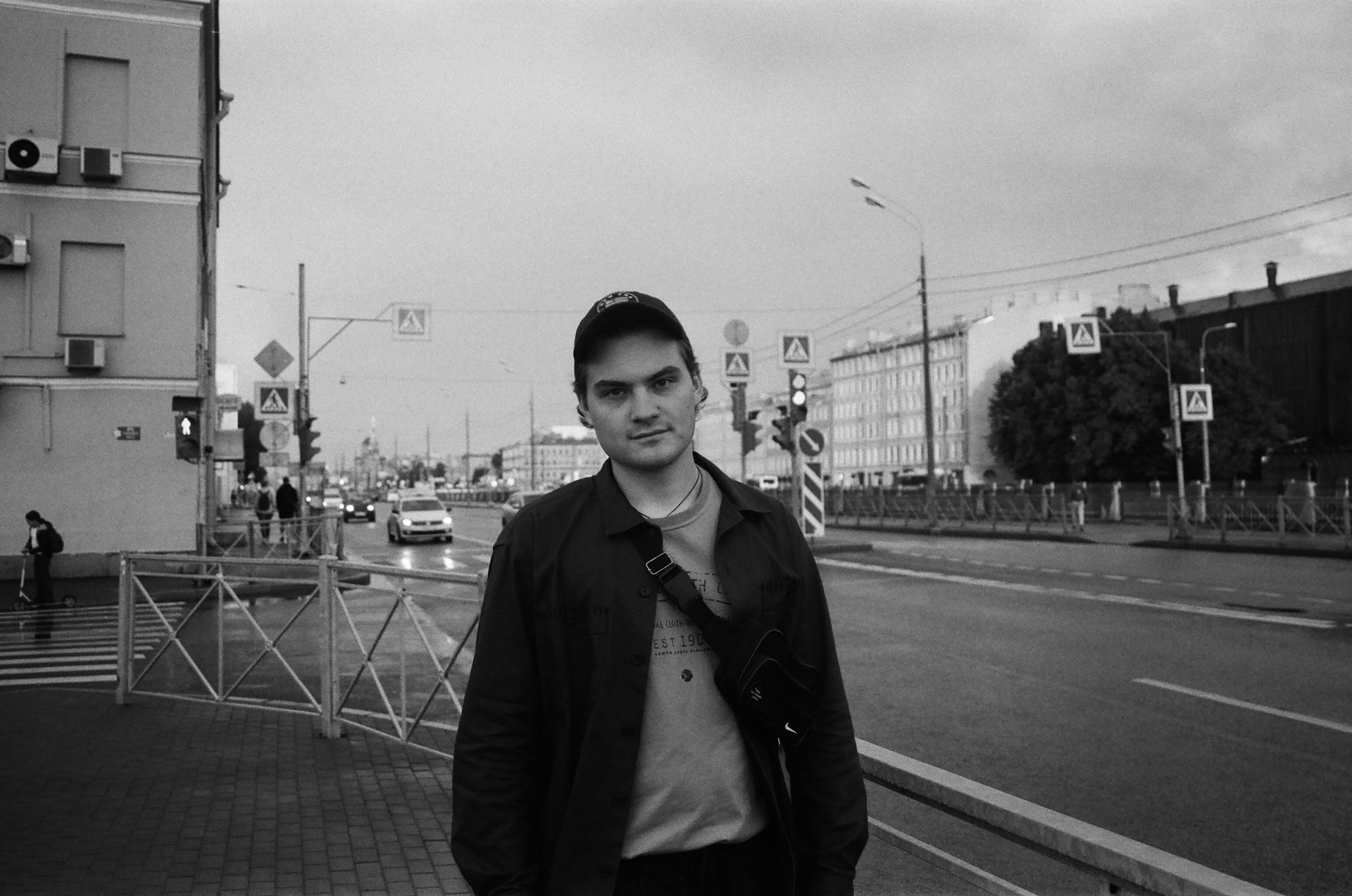 Man in Jacket Standing on the Side of the Road While Seriously Looking at Camera