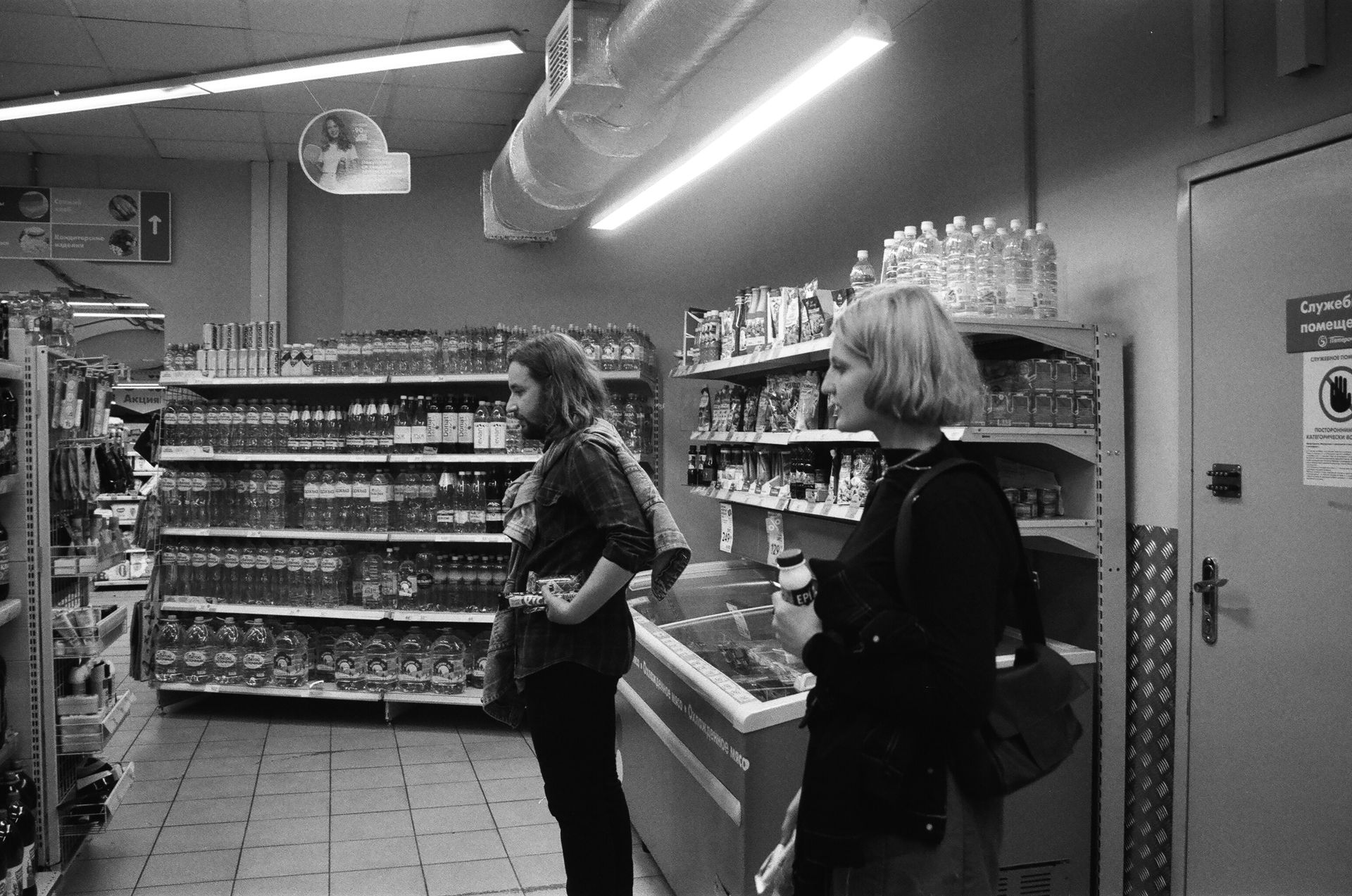 A Couple Looking at the Items on the Shelves of a Grocery Store