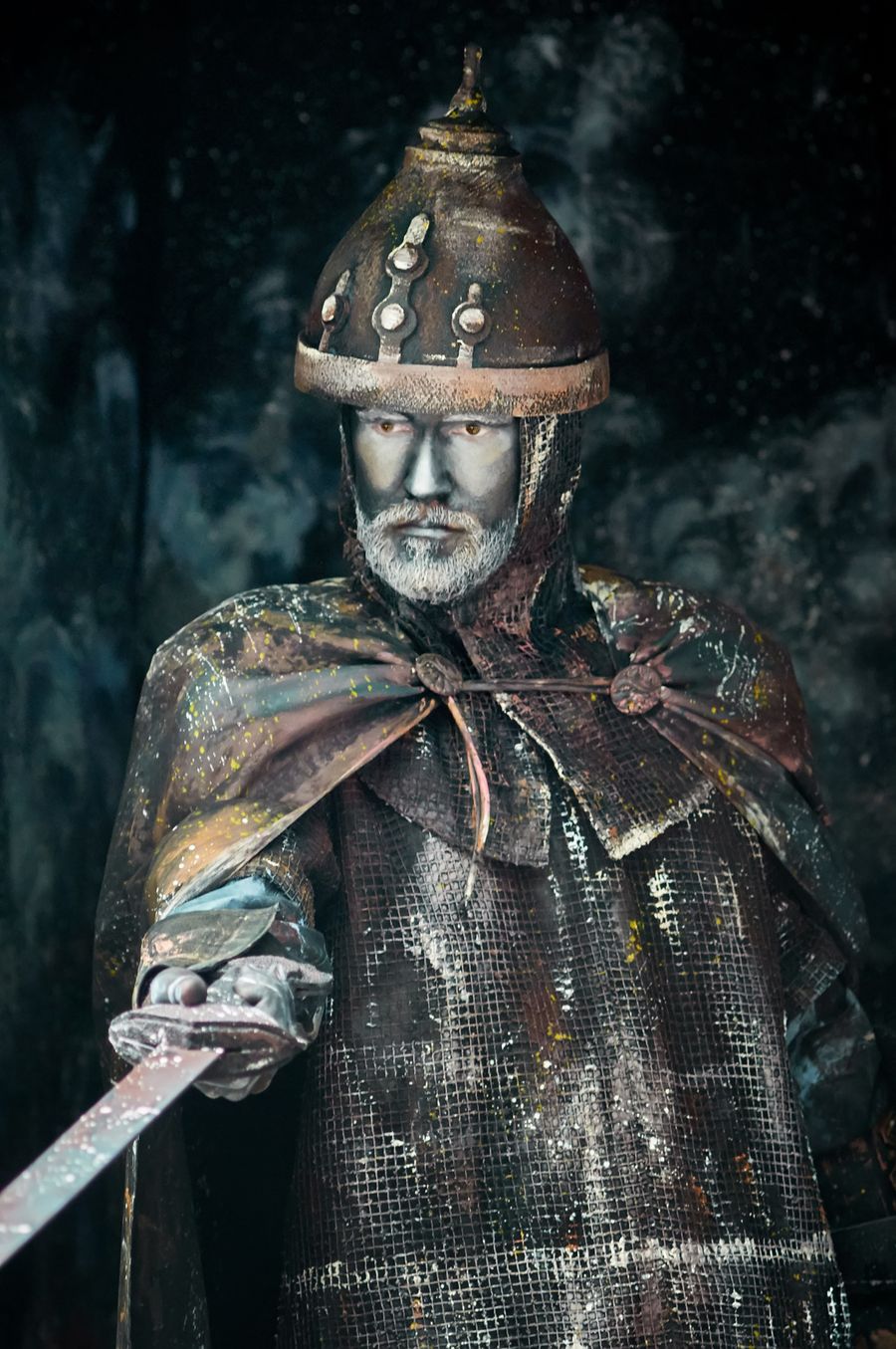 A warrior in historical armor holding a sword.