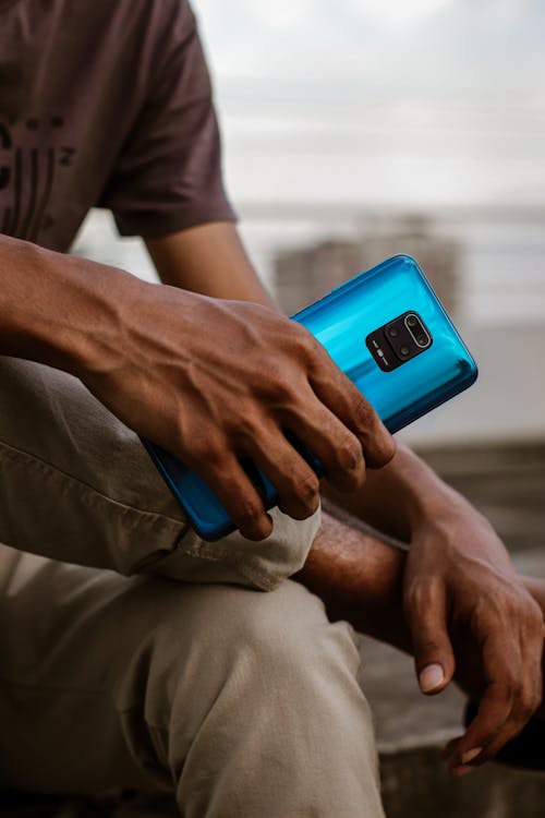 Free Close-Up Shot of a Person Holding a Blue Smartphone Stock Photo