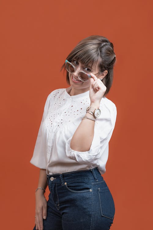 Woman Touching Her Sunglasses While Looking at the Camera