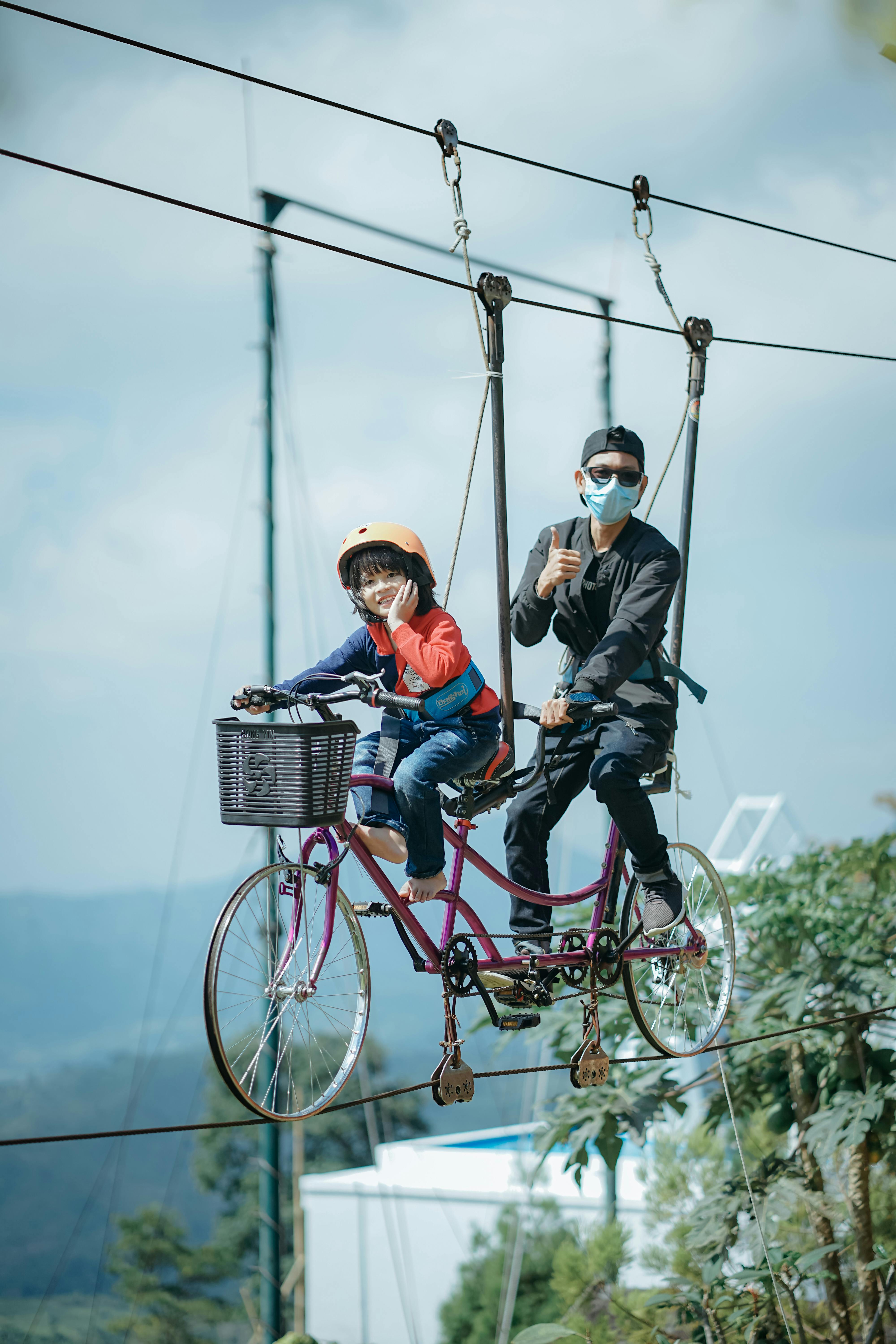 People Riding Bike Hanging on Ropes in Air · Free Stock Photo