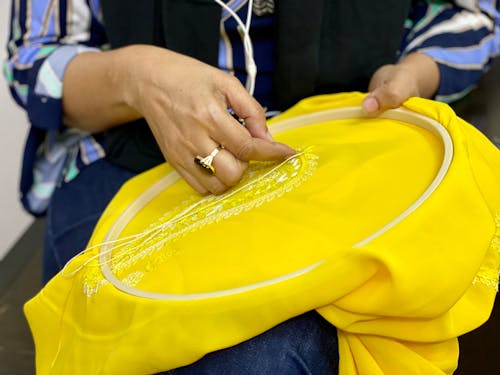 Free Close-Up Shot of a Person Sewing Yellow Textile Stock Photo