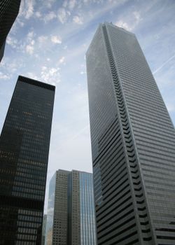 Tall skyscrapers in downtown Toronto reach toward a partly cloudy sky.