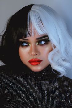 Striking portrait featuring bold makeup and black-and-white hair, showcasing artistic expression.