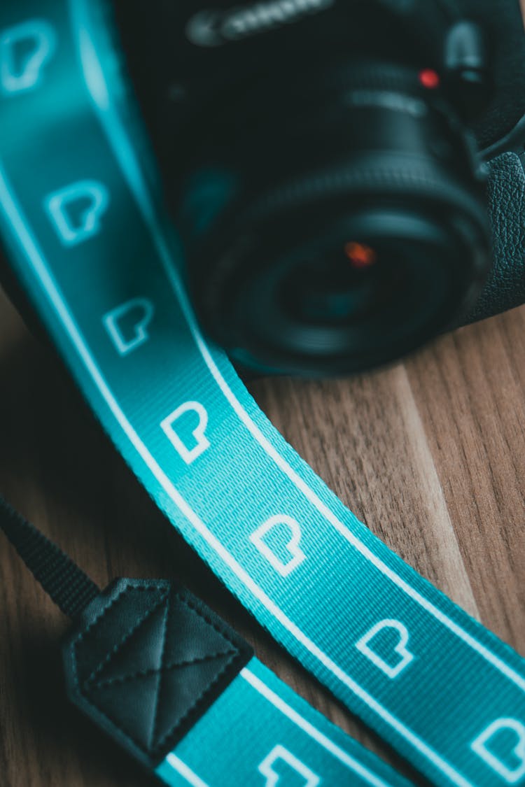 Black And Blue Camera Lens On Brown Wooden Table