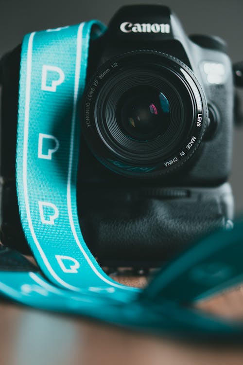 Free Close-Up Photo of a Camera Canon with a Green Strap Stock Photo