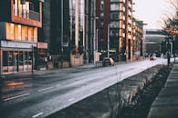 夜晚，这条城市街道道路潮湿，建筑物明亮，营造出都市氛围