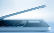 这款简约风格的现代笔记本电脑侧面图，凸显了其纤薄设计和技术亮点