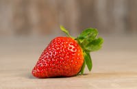 特写镜头中，一颗成熟的草莓充满活力，展现出新鲜度与鲜艳色彩