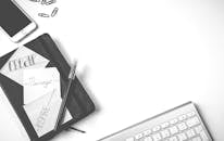 这张极简主义的扁平办公桌上，摆放着笔记本电脑、键盘和智能手机