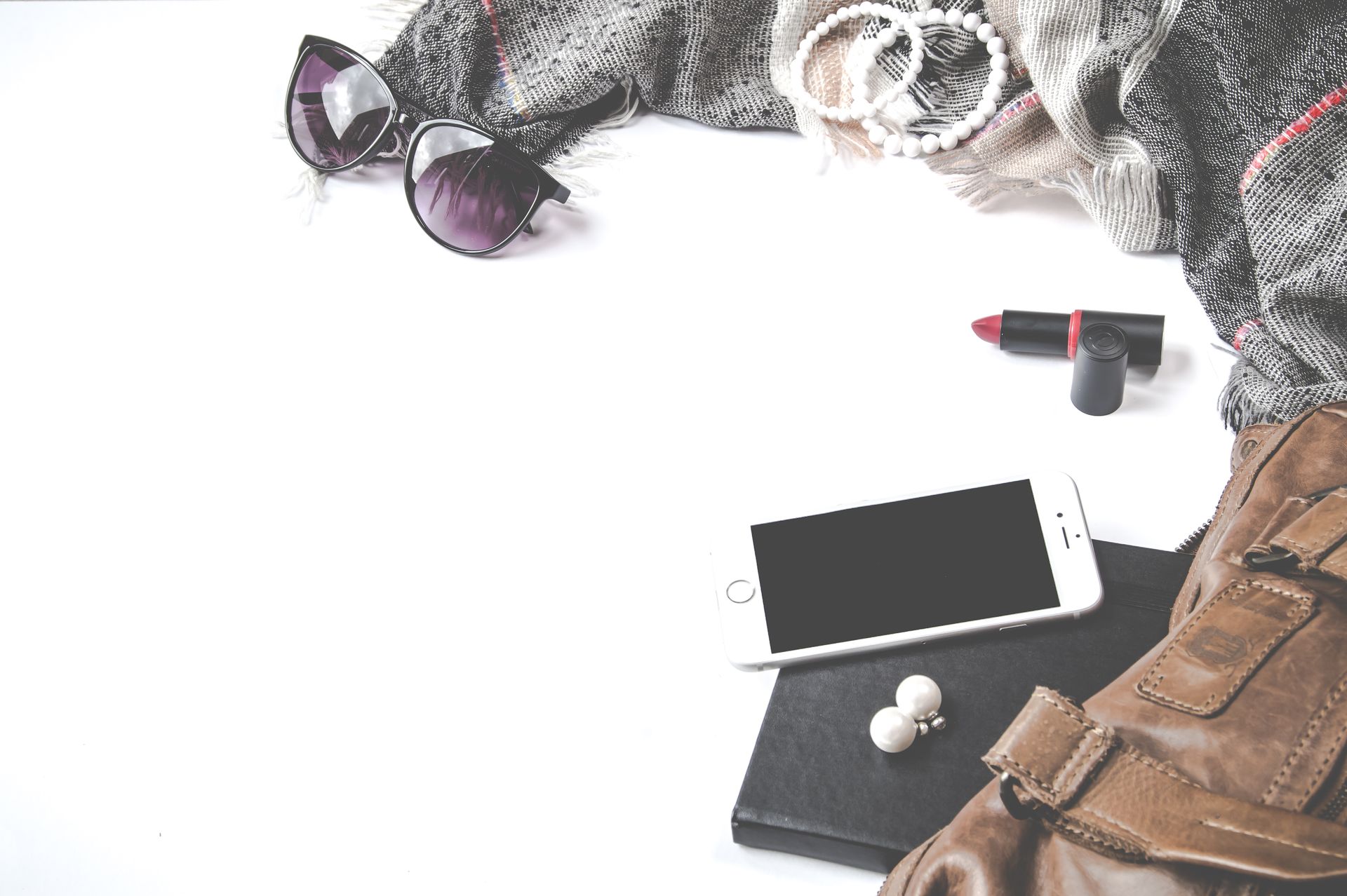 Stylish fashion flat lay with smartphone, sunglasses, and accessories.