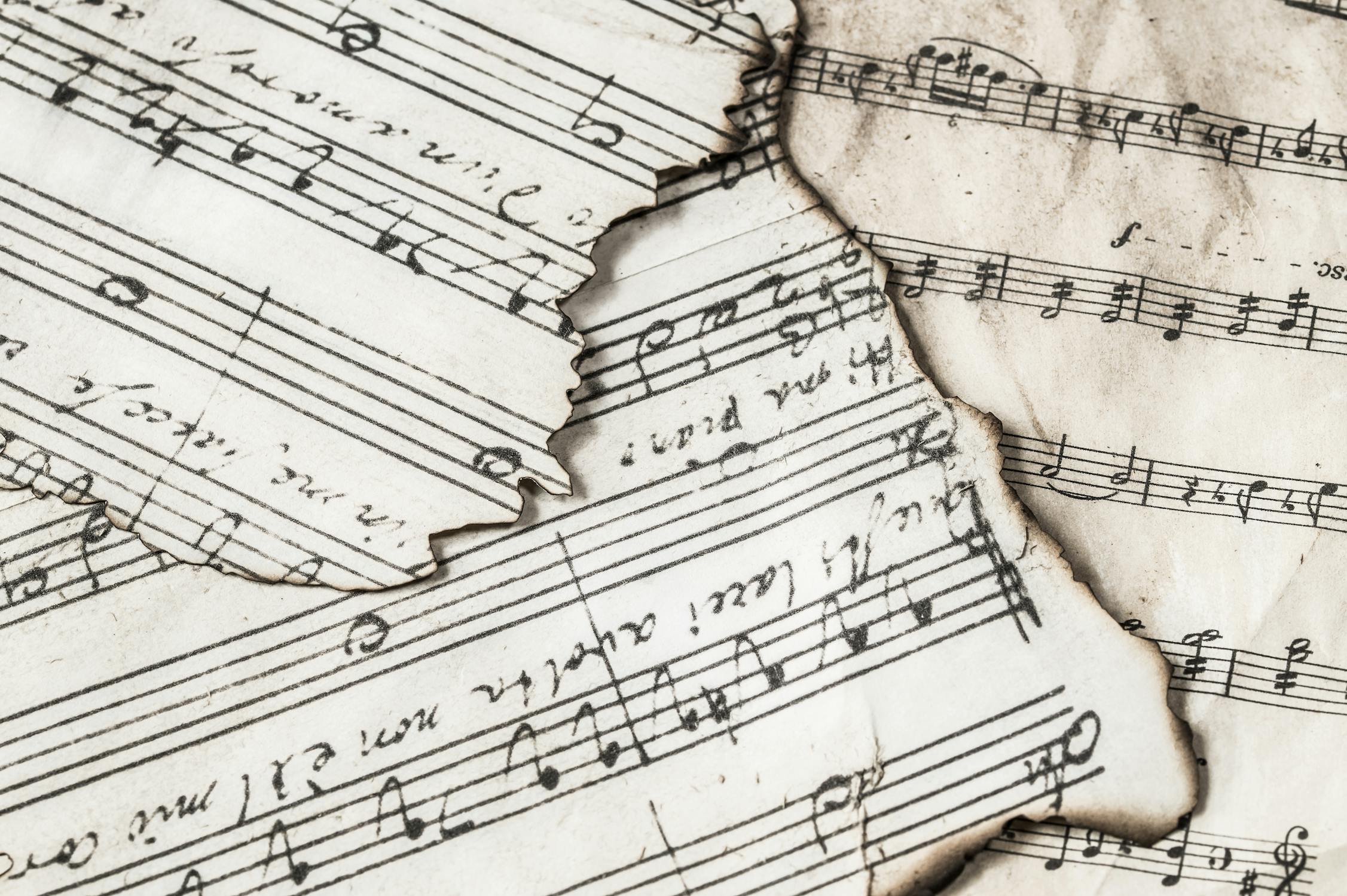 stacked pieces of weathered sheet music