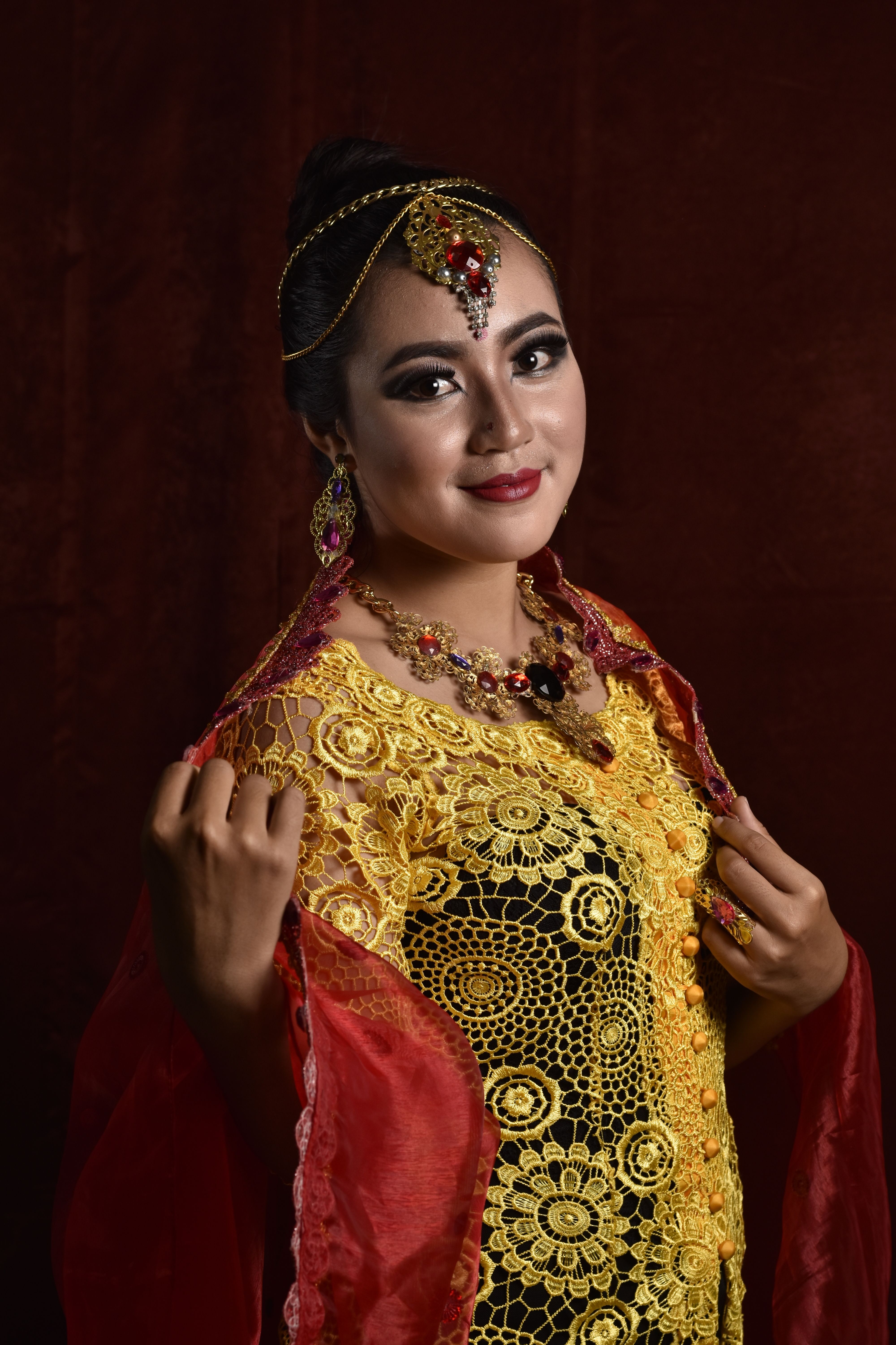 Portrait of a woman in a glamorous Indian saree with intricate gold embroidery, showcasing traditional elegance.