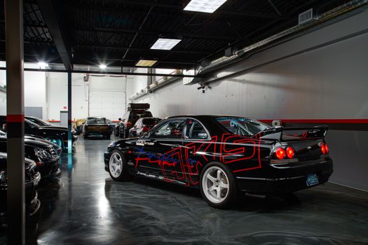 A collection of sports cars parked inside a modern garage, showcasing automotive design.