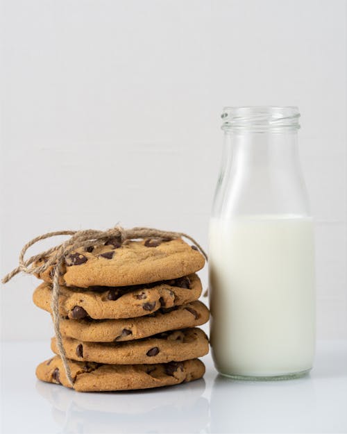 Free Photo of a Glass Bottle of Milk Beside a Stack of Cookies Stock Photo