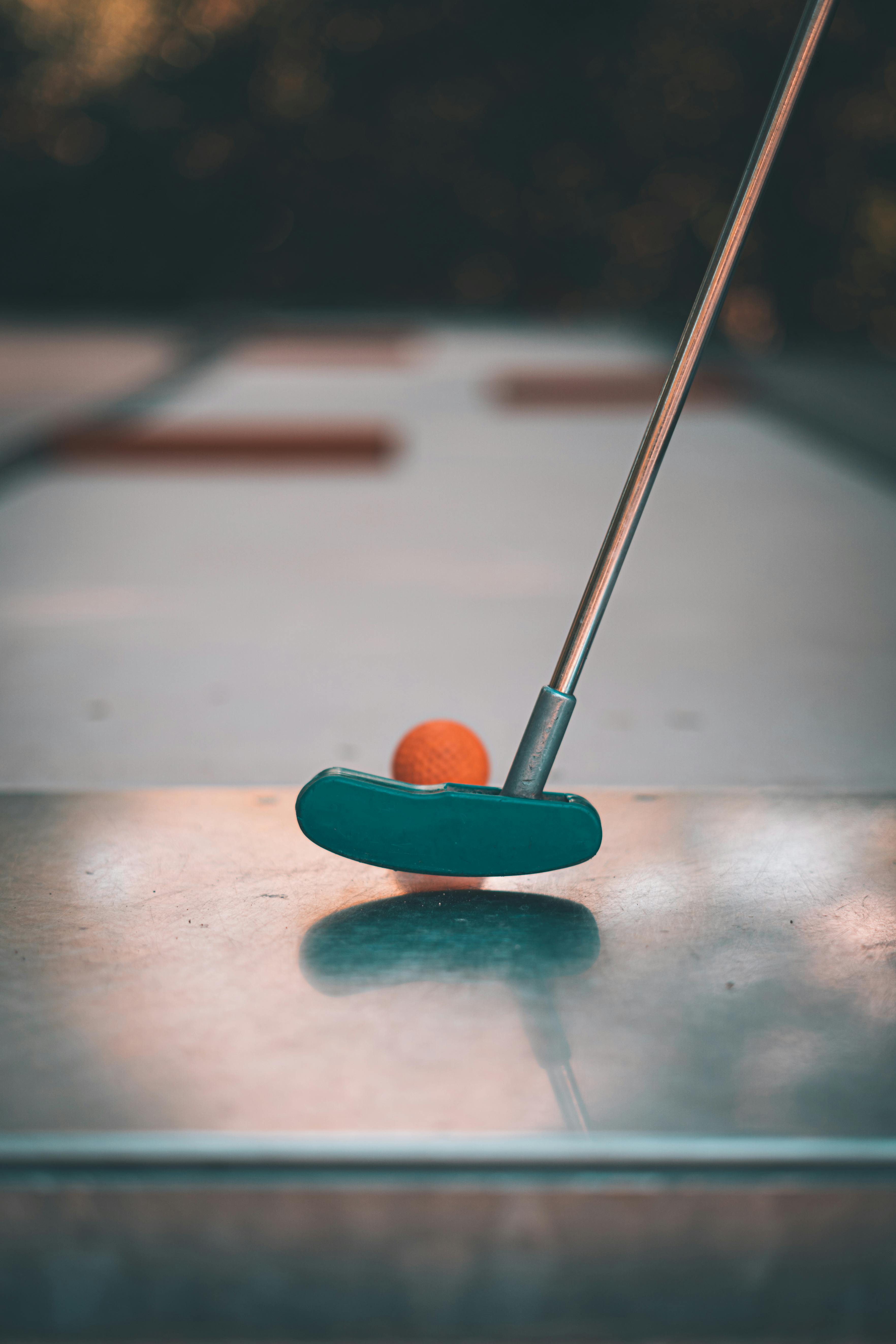 putter near a golf ball