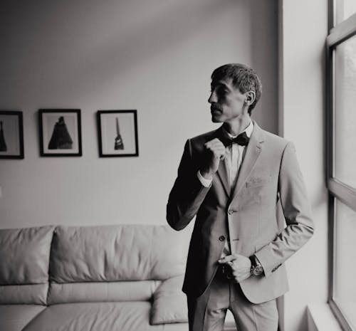 Free Man Wearing a Suit Standing Beside a Window Stock Photo