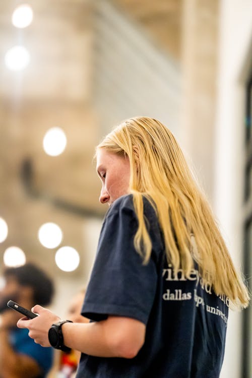 Woman in Blue Crew Neck Shirt Using Cellphone