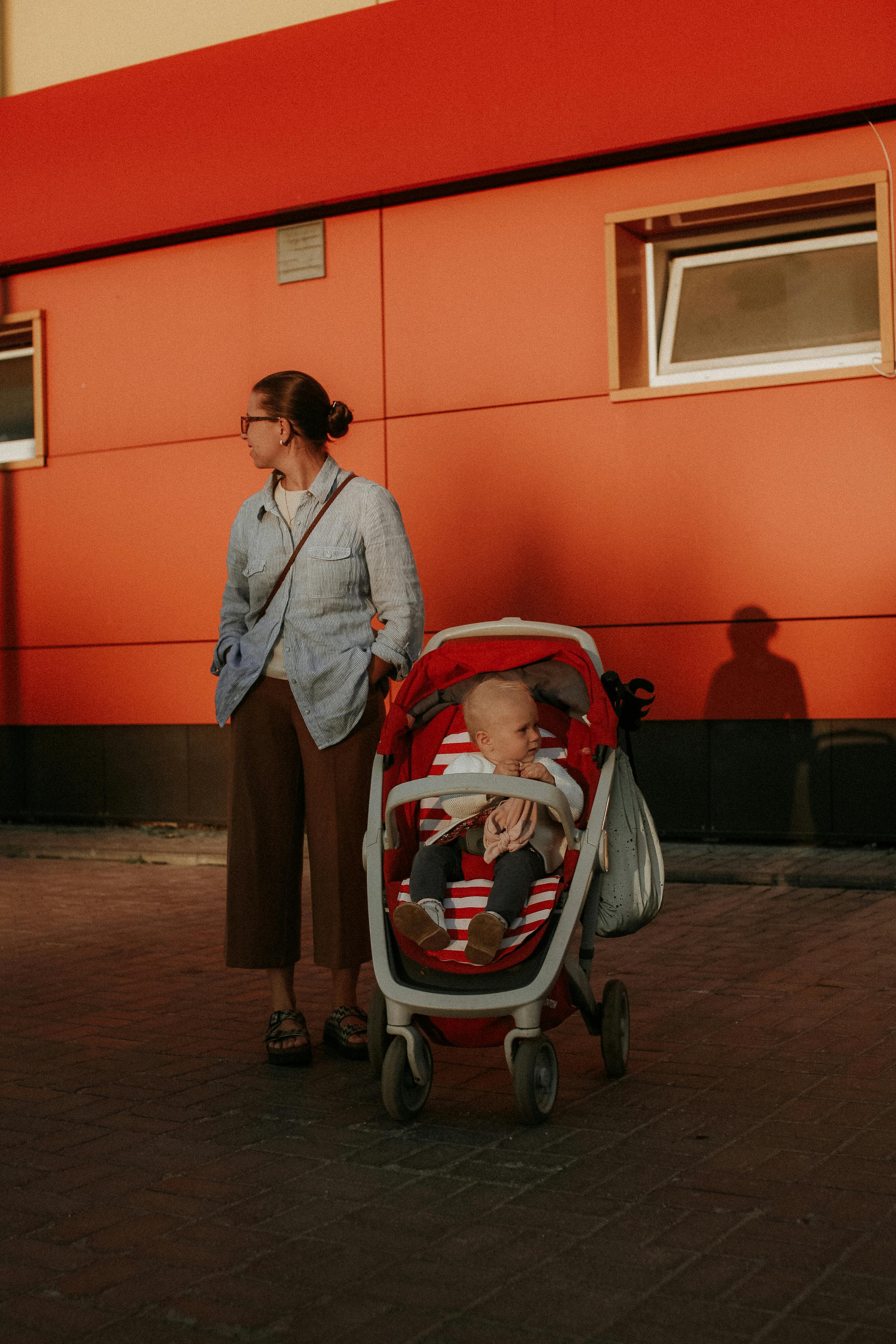 woman standing beside her baby in a stroller