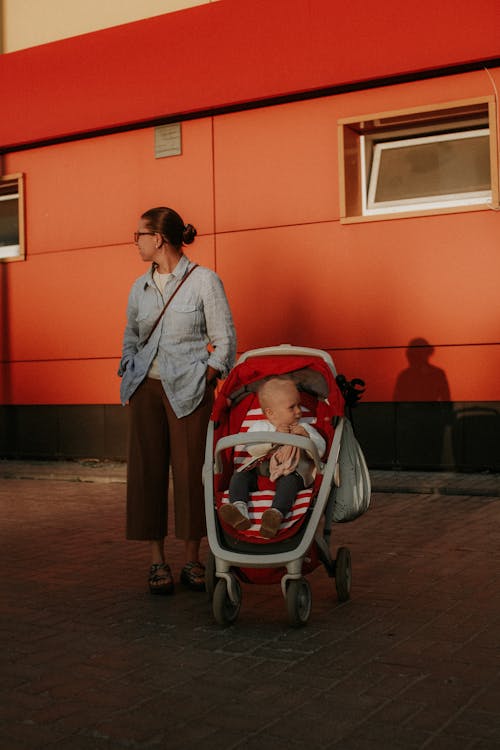 Free Woman Standing Beside Her Baby in a Stroller Stock Photo