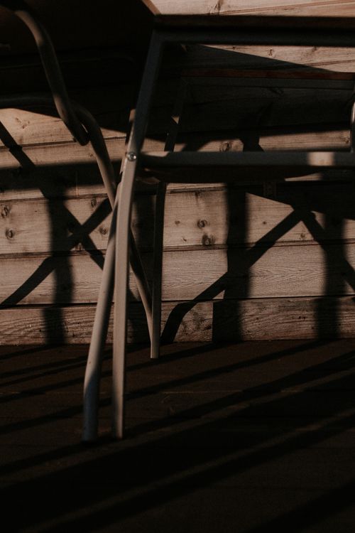 Free Intriguing composition of chair shadows on rustic wooden wall, perfect for artistic and conceptual themes. Stock Photo