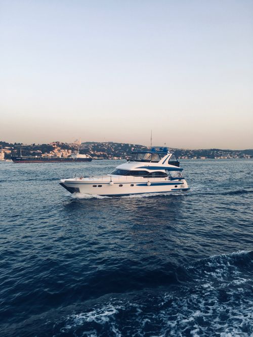 Free A sleek yacht navigates the serene waters of Turkey with a picturesque coastal backdrop. Stock Photo
