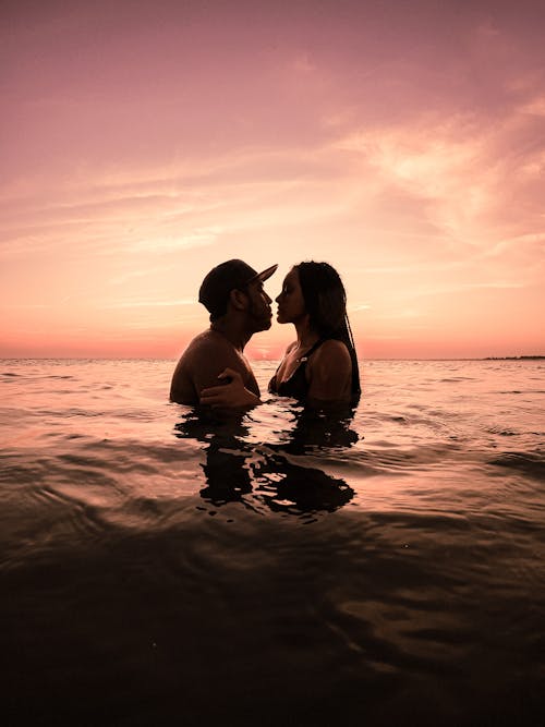 Romantic Couple Kissing on Sea during Sunset