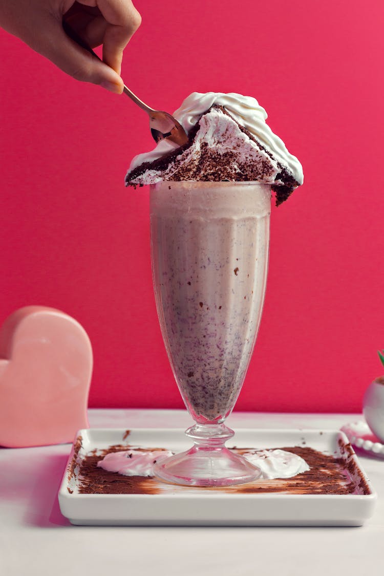 Person Scooping Ice Cream In Clear Glass Cup