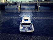 白天，高角度拍摄的渡轮在混凝土桥下的城市河流上行驶