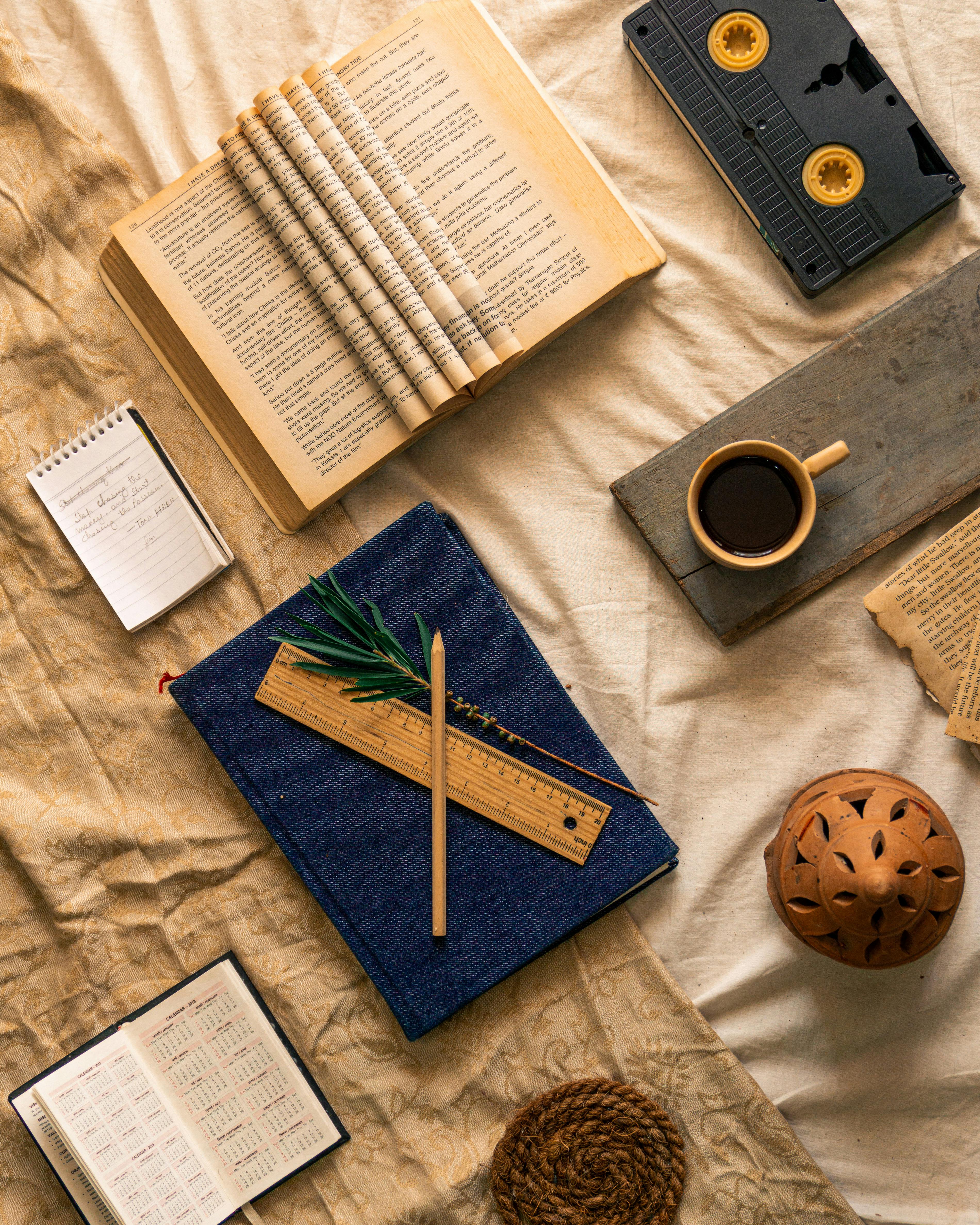 Flat Lay with Books and Journals on Bed Sheets · Free Stock Photo