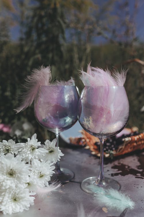 Garden Table Decoration Made of Wineglasses Flowers and Feathers