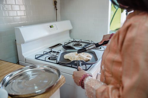 Person Cooking on White Stove
