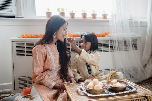 Free 2 Women Sitting on Chair Eating Stock Photo